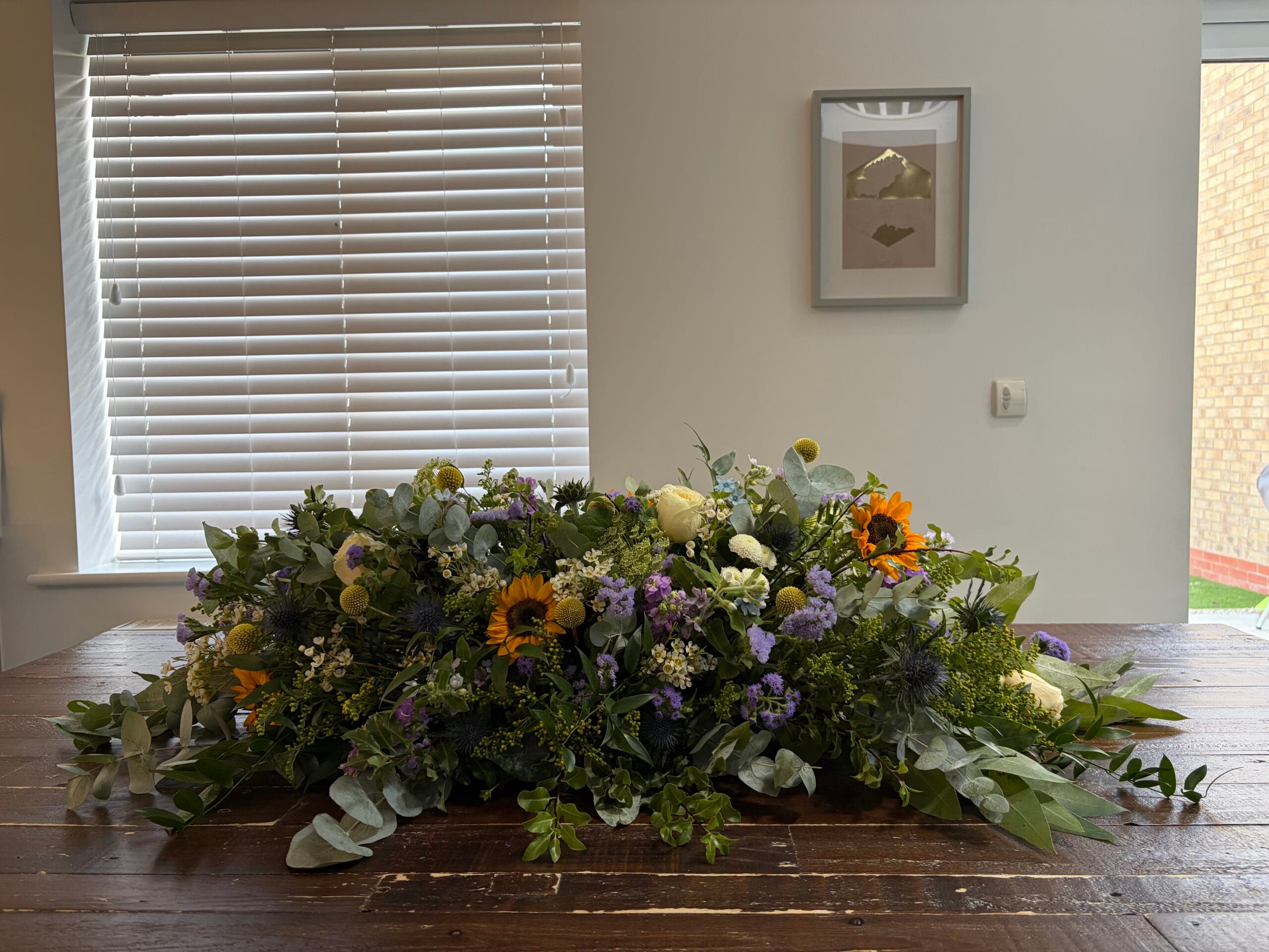 Double ended coffin spray with sunflowers, thistles and eucalyptus by Tiny Petal Studio