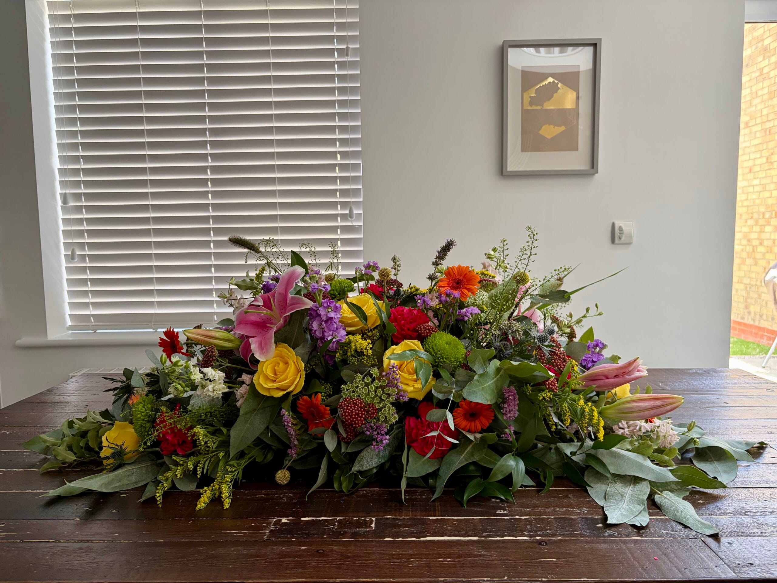 Colourful double ended coffin spray with roses, lilies and gerberas