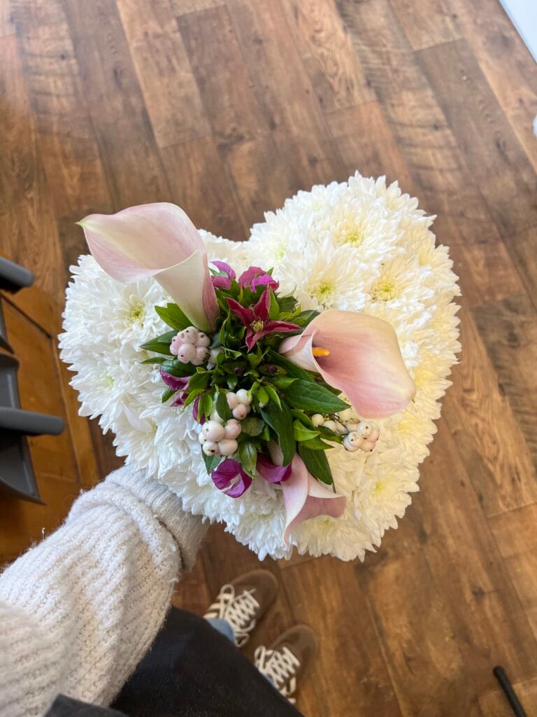 Heart shaped funeral tribute in white chrysanthemums with calla lilies