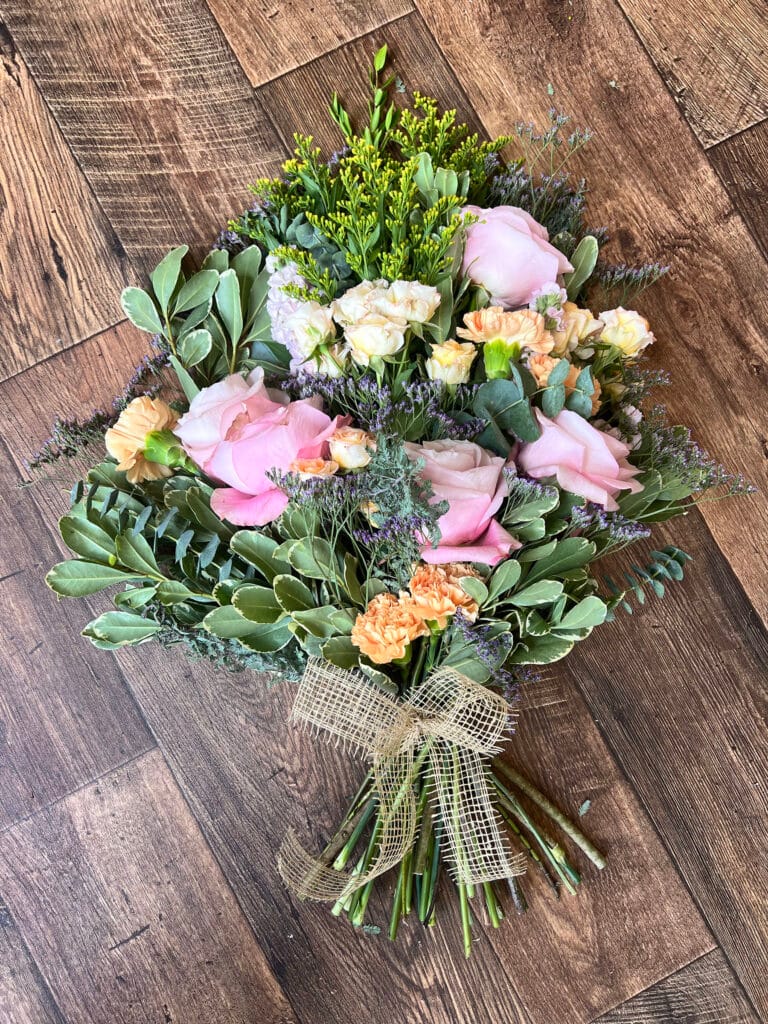 Colourful bouquet of flowers on wooden floor.
