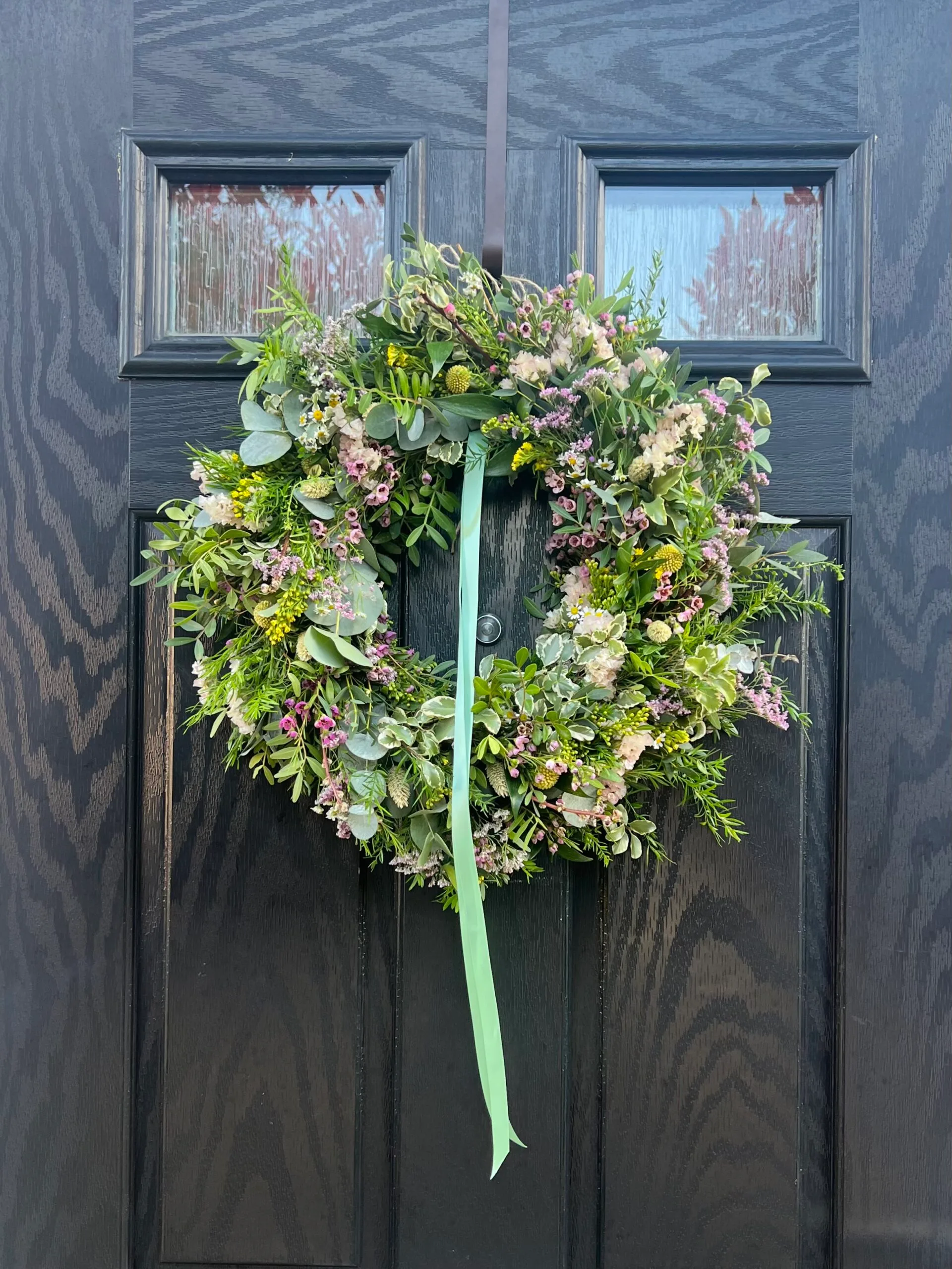 Floral wreath on dark wooden door